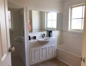 a bathroom with a sink and a tub and a mirror at Kingston apartment in Kingston