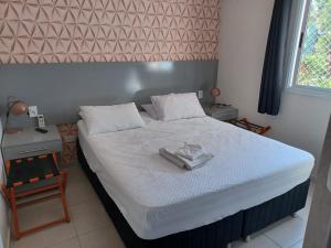 a bedroom with a bed with a towel on it at Riviera de São Lourenço Boulevard Travel inn in Bertioga +30 photos