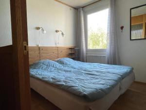 a bedroom with a bed with a blue bedspread and a window at 5 person holiday home in Mörlunda-By Traum in Tulunda