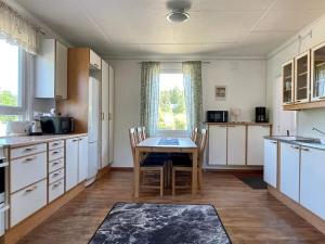 a kitchen with white cabinets and a table and chairs at 5 person holiday home in Mörlunda-By Traum in Tulunda