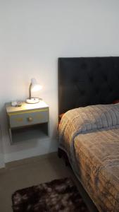 a bedroom with a bed and a table with a lamp at Bonaires V departamento monoambiente cerca de la costanera in Corrientes +7 photos