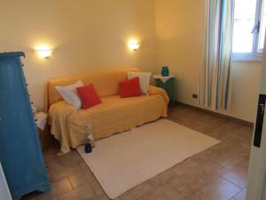 sala de estar con sofá amarillo y 2 almohadas rojas en Appartamento mare mare, en Forza dʼAgro