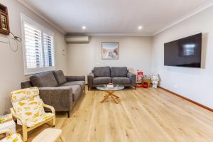 バッセルトンにあるOpal Laneのソファ2つとテレビのあるリビングルーム