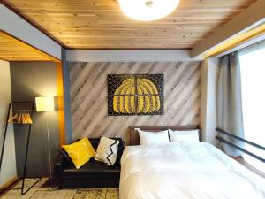 ein Schlafzimmer mit einem Bett und einer Couch in der Unterkunft ゲストハウスsimasima古馬場301 in Takamatsu