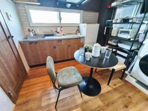 eine kleine Küche mit Tisch und Stühlen in einem Zimmer in der Unterkunft ゲストハウスsimasima古馬場301 in Takamatsu