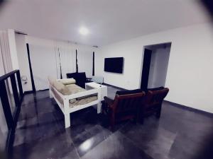 a living room with a bed and a tv at Oceana Suites Elisio Mouriño in La Unión