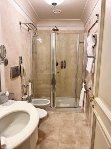 a bathroom with a shower and a toilet and a sink at Grand Hotel Continental Siena - Starhotels Collezione in Siena