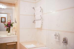 a white bathroom with a sink and a toilet at Grand Hotel Continental Siena - Starhotels Collezione in Siena +78 photos