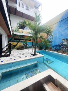 eine Palme mitten im Swimmingpool in der Unterkunft Hotel Coralite Suites Lions in Santa Marta