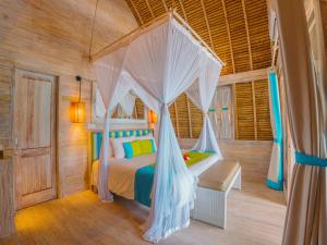 a bedroom with a bed with a mosquito net at Hai Tide Beach Resort in Nusa Lembongan