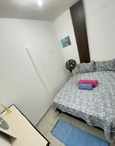 a bedroom with a bed and a desk with a fan at Kitnet Dream House 1 in Bayeux