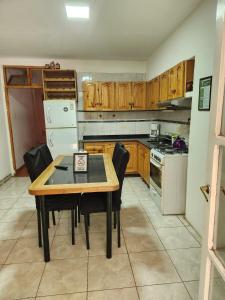a kitchen with a table and chairs and a refrigerator at alojamiento la pipi in Las Heras