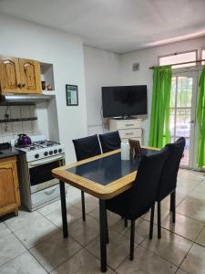 a kitchen with a table and chairs and a television at alojamiento la pipi in Las Heras