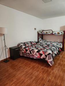 a bedroom with a bed in a room with a wooden floor at alojamiento la pipi in Las Heras