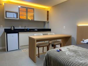 a kitchen with a table and chairs in a room at LINDO LOFT 350m Vila Germânica in Blumenau