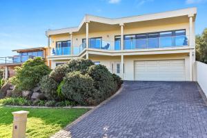 a house with a driveway in front of it at 13 The Crescent - BYO Linen - Ocean Views - Wi-Fi in McCracken