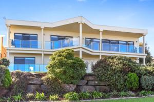 an apartment building with a balcony and bushes at 13 The Crescent - BYO Linen - Ocean Views - Wi-Fi in McCracken