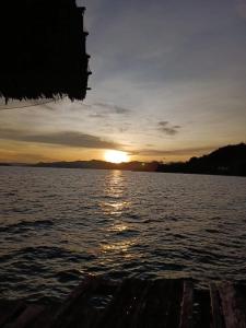 einen Sonnenuntergang über einem Wasserkörper mit einem Boot in der Unterkunft Full Board Raja Ampat Sanara Homestay in Waisai + 1 Foto