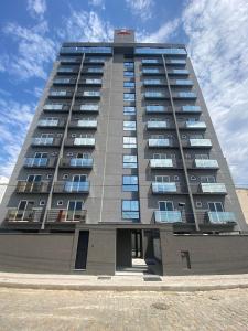 a tall building with windows on the side of it at LINDO LOFT 350m Vila Germânica in Blumenau