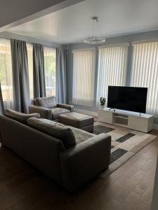 a living room with a couch and a flat screen tv at Cozy and stylish 3BR house in Tacoma