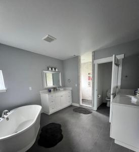 a bathroom with a white tub and a sink at Cozy and stylish 3BR house in Tacoma