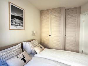 a bedroom with a bed with white sheets and pillows at Zentrale Oase, Ski, Berge Spass, 45m2, für 2P - C8 in St. Moritz