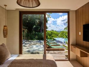 a bedroom with a sliding glass door leading to a pool at Villa Das Contas Boutique in Itacaré