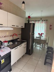 a kitchen with a sink and a refrigerator and a table at Residencial lara 101 in Itapema