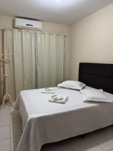 a bedroom with a bed with two towels on it at Residencial lara 101 in Itapema