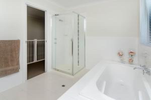 a white bathroom with a tub and a glass shower at Isla Bonita - Pet Friendly - Not Fully Fenced - No Linen Included in Hindmarsh Island +10 photos