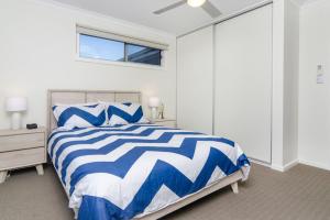 a bedroom with a blue and white bed and a window at Isla Bonita - Pet Friendly - Not Fully Fenced - No Linen Included in Hindmarsh Island