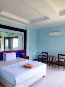 una camera da letto con un letto, un tavolo e delle sedie di Citepus Indah Hotel a Citepus