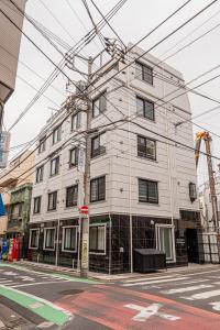 ein großes weißes Gebäude an einer Stadtstraße in der Unterkunft Mi-HOTEL SHIMOKITAZAWA in Tokio