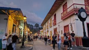 a crowd of people walking down a street with a clock at Hotel La Caracola Salento in Salento