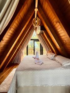 a bed in a room with a ceiling at Chalé Bela Vista - Três Cachoeiras in Três Cachoeiras