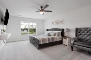 Schlafzimmer mit einem Bett, einem Deckenventilator und einem Stuhl in der Unterkunft Perfect spot for Savannah vacation! in Port Wentworth + 114 Fotos