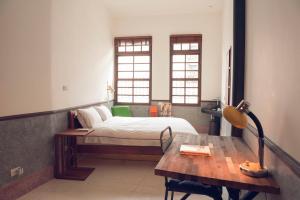 a bedroom with a bed and a desk and a table at OrigInn Space in Taipei