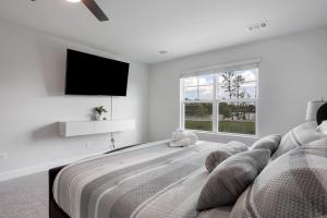 ein Schlafzimmer mit einem großen Bett und einem Flachbildfernseher in der Unterkunft Perfect spot for Savannah vacation! in Port Wentworth