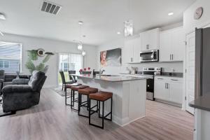 eine Küche mit weißen Schränken und eine Bar mit Hockern in der Unterkunft Perfect spot for Savannah vacation! in Port Wentworth