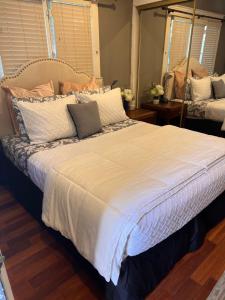 uma cama grande com lençóis e travesseiros brancos em The Perfect studio em Riverside