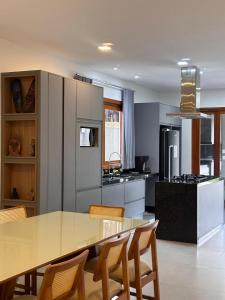 a kitchen with a table and chairs in a kitchen at Casa térrea moderna em condomínio in Bertioga