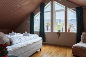 a bedroom with a bed and two large windows at ARCTIC HOMES - The Spacious Villa in Tromsø