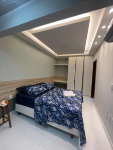 a bedroom with a bed with a blue comforter at Ap 304 Via Mares do Frances in Marechal Deodoro +32 photos