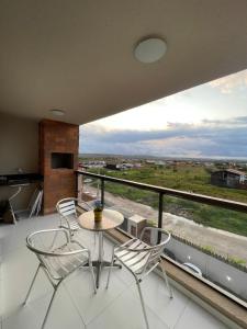 a balcony with a table and chairs and a large window at Ap 304 Via Mares do Frances in Marechal Deodoro