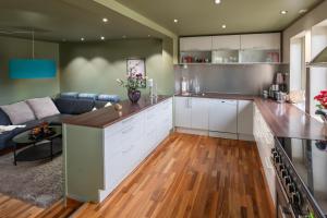 a kitchen with white cabinets and a living room at ARCTIC HOMES - The Spacious Villa in Tromsø +20 photos