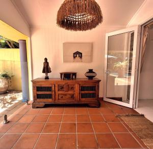 a room with a wooden cabinet and a chandelier at Studio Casablanca in Nelly Bay