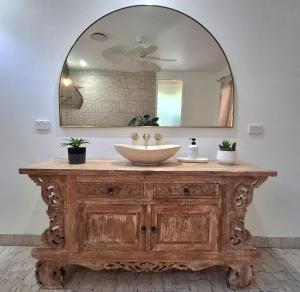 a bathroom vanity with a sink and a mirror at Studio Casablanca in Nelly Bay