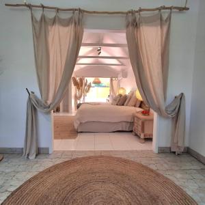 a bedroom with a bed and curtains in a room at Studio Casablanca in Nelly Bay