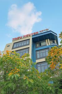 Tân UyênにあるTriệu Nguyễn Hotelの上に看板がある建物