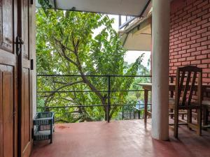 a balcony with a table and a tree at New Green View Guest House Kithal Ella in Badulla +26 photos